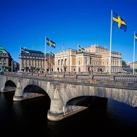 Swedish National Flags flying over the Norrbro bridge and the Royal Opera house in Stockholm